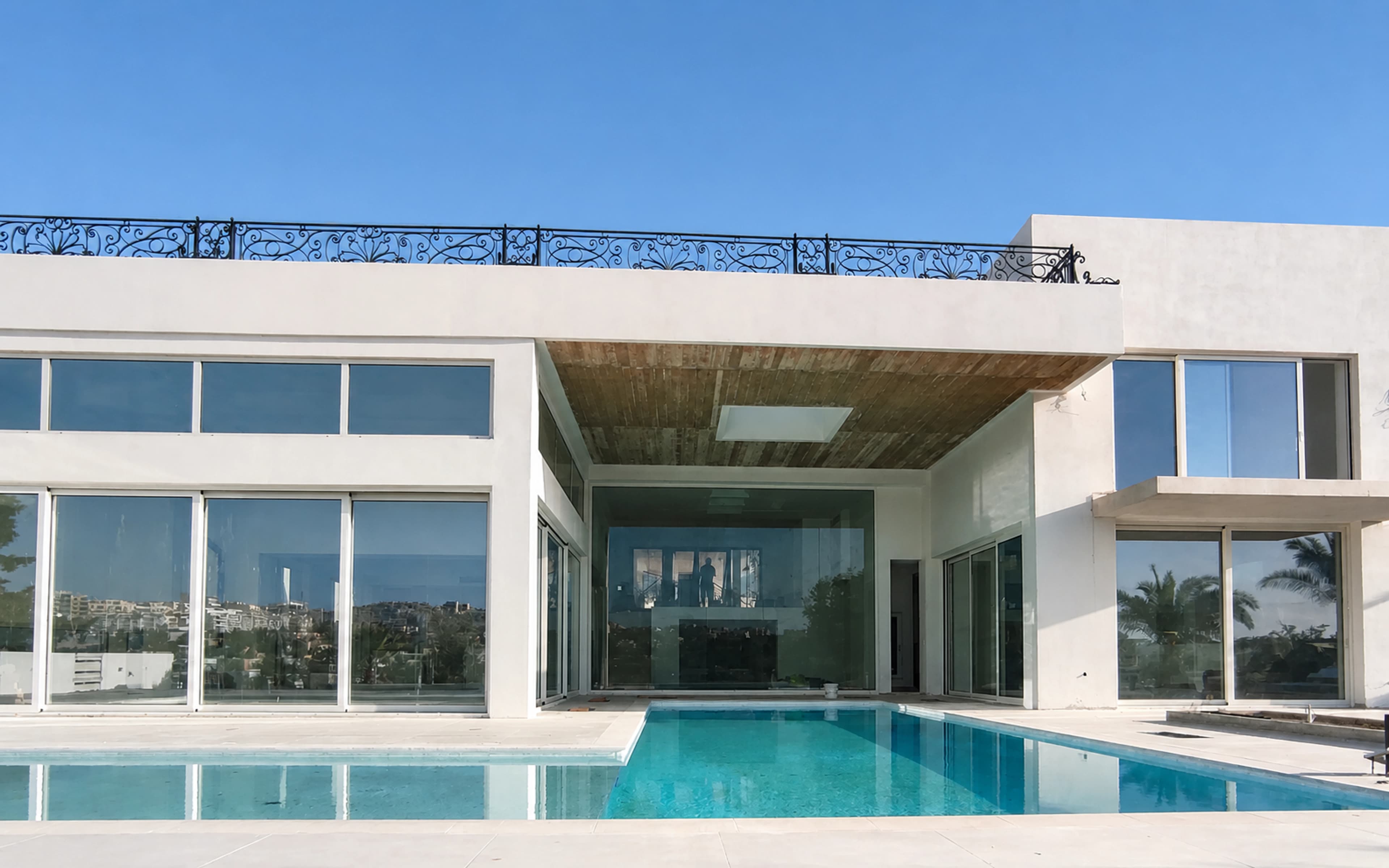Modern villa with a full glazed elevation reflected in a pool
