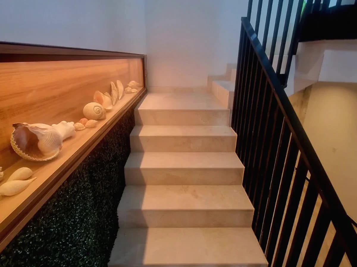 Interior stair with a black balustrade and illuminated display niche